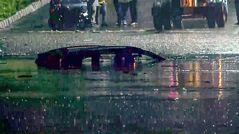 A vehicle is seen submerged in a severely waterlogged area after heavy rainfall in several parts of the region, at Minto Road in New Delhi on Sunday.