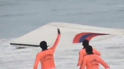 Lifeguards surround the overturned boat.