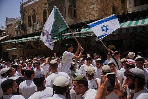 Israelis wave national flags during a march marking Jerusalem Day, an Israeli holiday celebrating the capture of east Jerusalem in the 1967 Mideast war, in Jerusalem's Old City, Monday, May 26, 2025.