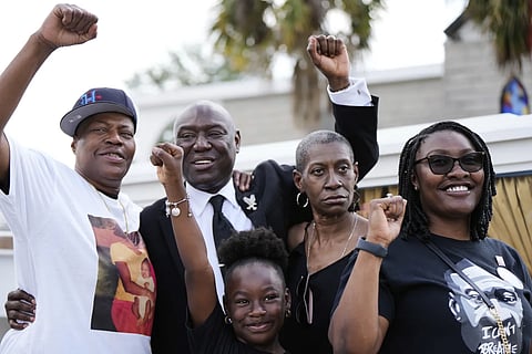 Attorney Ben Crump, second from left, raises his fist with George Floyd's sisters, LeTonya Floyd, left, and Zsa Zsa Floyd, second from left, along with great niece Arianna Williams, 7, and niece Bianca Williams, right before a memorial service on the anniversary of Floyd's death on Sunday, May 25, 2025, in Houston.