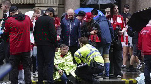 A police officer speaks with a man at the site of an incident on Water Street near the Liver building in Liverpool after a car collided with pedestrians during the Premier League winners parade, in Liverpool, England, Monday, May 26, 2025.