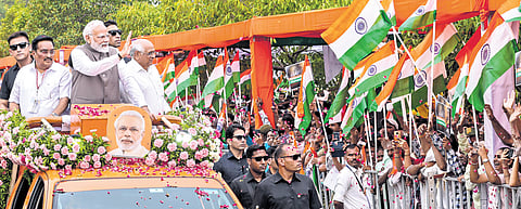 Prime Minister Narendra Modi waves at supporters during a roadshow in Gandhinagar, Gujarat, on Tuesday.