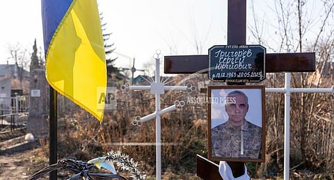 A portrait of Serhii Hryhoriev, a Ukrainian prisoner of war who died in Russia, is seen next to his grave in Pyriatyn, Ukraine, March 9, 2025.