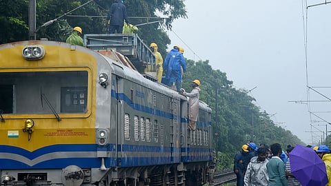 Railway officials to clear a fallen tree that blocked the railway track near Kozhikode, ensuring safe passage for trains after heavy rains triggered the obstruction