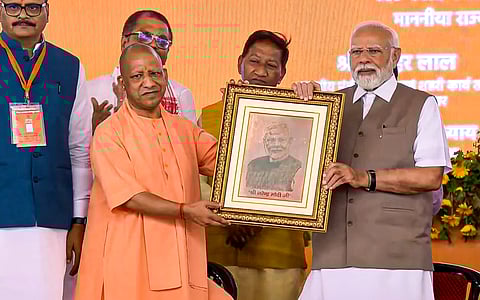 Prime Minister Narendra Modi being felicitated by Uttar Pradesh Chief Minister Yogi Adityanath during the inauguration and foundation stone laying of various development projects at a public meeting, in Kanpur.