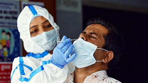A health worker collects a swab sample for the Covid-19 test at a hospital in New Delhi.