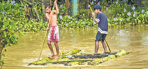 Locals row their makeshift raft at a flood-affected area while moving to a safer place, in Lakhimpur district, Assam.