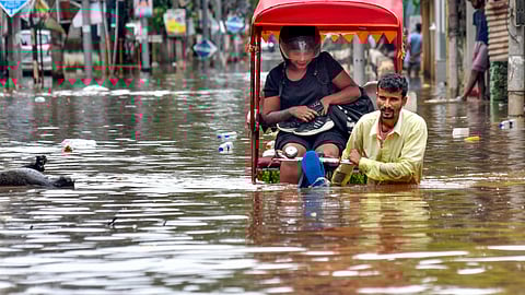 A man pulls his rickshaw as he wades through a waterlogged road after heavy rainfall, in Guwahati, Assam, May 31, 2025.