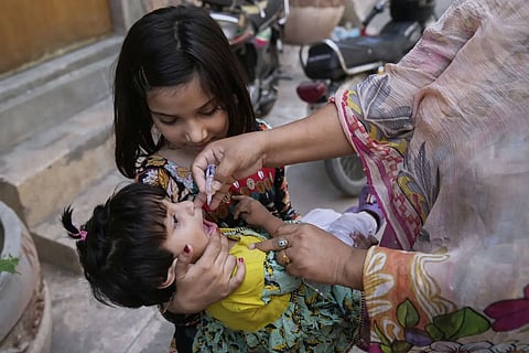 A health worker administers a polio vaccine to a child at a neighbourhood, in Lahore, Pakistan, Monday, May 26, 2025.