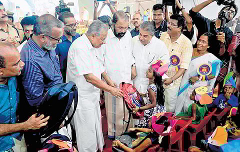 Chief Minister Pinarayi Vijayan handing over a school bag to a girl before the inauguration of state-level Praveshanotsavam at Government Higher Secondary School in Kalavoor, Alappuzha, on Monday