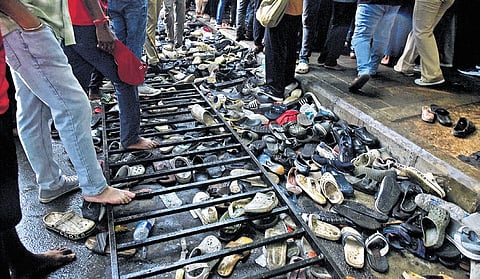 Footwear of spectators lie scatered outside M Chinnaswamy Stadium.