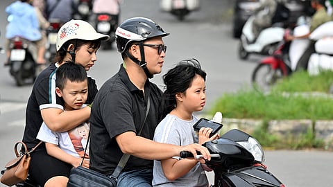 A family rides a motorcycle along a street in Hanoi on June 4, 2025.