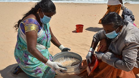Workers manually segregate tiny plastic pellets called nurdles from Chothuvilai beach sand.