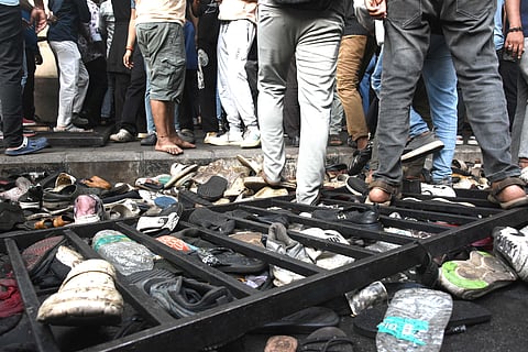 Fans stand next to abandoned shoes and a fallen barrier following a stampede during celebrations, a day after Royal Challengers Bengaluru's victory at the Indian Premier League (IPL) Twenty20 final cricket match, outside the M. Chinnaswamy Stadium in Bengaluru on June 4, 2025.
