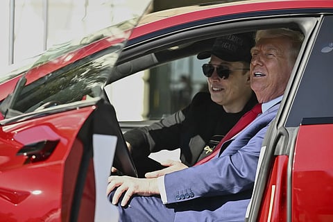 US President Donald Trump and Tesla CEO Elon Musk speak to reporters as they sit in a red Model S Tesla vehicle on the South Lawn of the White House, March 11, 2025, in Washington.