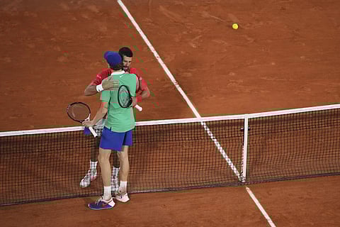 Winner Italy's Jannik Sinner, back to the camera, and Serebia's Novak Djokovic hug after their semifinal match of the French Tennis Open at the Roland-Garros stadium in Paris, Friday, June 6, 2025.
