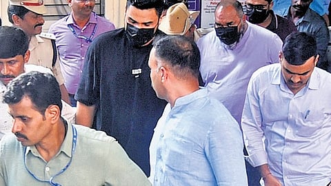 RCB marketing head Nikhil Sosale (black T-shirt) and three employees of DNA Entertainment Networks Pvt Ltd at the Cubbon Park police station in Bengaluru after their arrest from the Kempegowda International Airport on Friday.