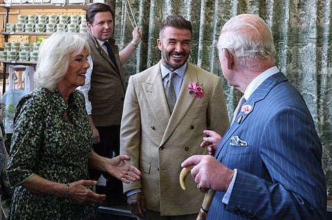 Britain's Queen Camilla (L) and Britain's King Charles III (R) speak with businessman and retired football player David Beckham as they visit the preview day at the RHS Chelsea Flower show, in London, on May 19, 2025.
