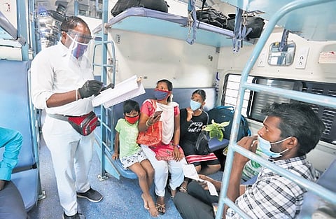 A TTE checking tickets of passengers on a train.