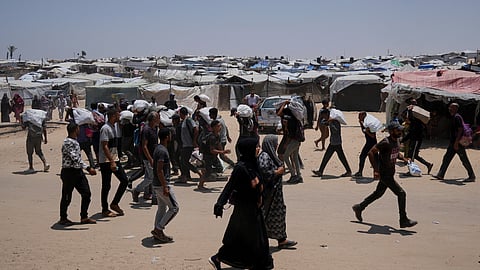 Palestinians carry bags containing food and humanitarian aid packages delivered by the Gaza Humanitarian Foundation, a U.S.-backed organization, in Rafah, southern Gaza Strip, Sunday, June 8, 2025