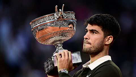 Spain's Carlos Alcaraz holds the trophy after winning the men's singles final match against Italy's Jannik Sinner on day 15 of the French Open tennis tournament on Court Philippe-Chatrier at the Roland-Garros Complex in Paris on June 8, 2025.