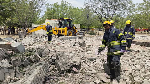 Rescue personnel at the accident site after dousing the fire.