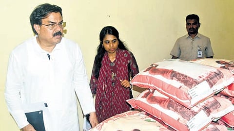 Civil Supplies Minister N Manohar inspects fine rice bags for mid-day meals.