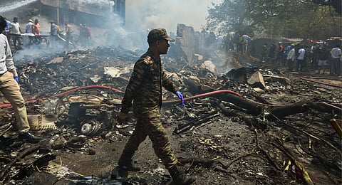 A security man at the site after an Air India plane crashed moments after taking off from the airport, in Ahmedabad.