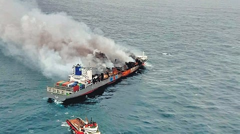 Tug Ocean Warrior holding the towline to keep burning container vessel Wan Hai stable