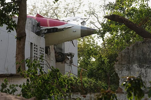 The tail of the airplane is seen stuck in a building at the site of an airplane that crashed in India’s northwestern city of Ahmedabad in Gujarat state, Thursday, June 12, 2025.