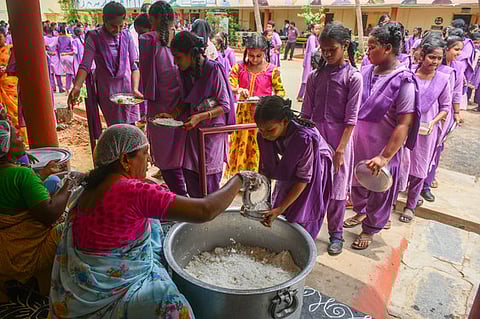 School students have mid-day meals at a government school which is cooked with fine quality fortified rice in Vijayawada on Friday.