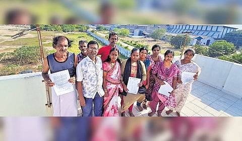 Sathiyavani Muthu Nagar residents pose with the paper of research findings from samples obtained from the vicinity of the nearby fertiliser unit