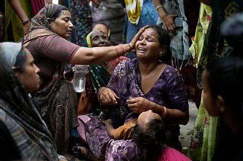 A relative of a victim of the Air India plane crash is comforted as she breaks down at a hospital in Ahmedabad, India, Friday, June 13, 2025.