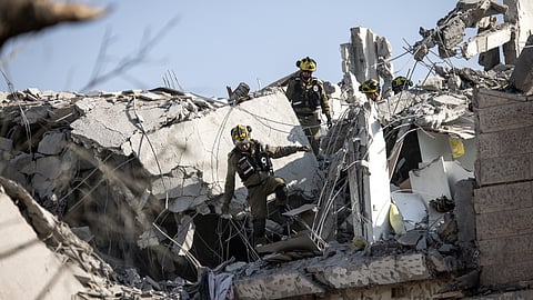 Israeli emergency responders inspect a site hit by a missile fired from Iran south of Tel Aviv on June 14, 2025.