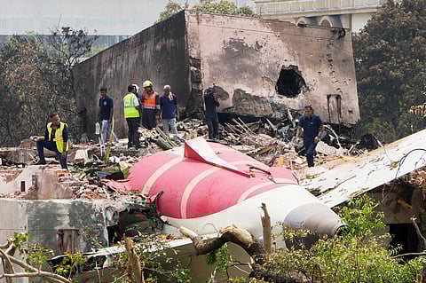 Officials inspect the site of Thursday's Air India plane crash on the roof of a building in Ahmedabad, Friday, June 13, 2025.