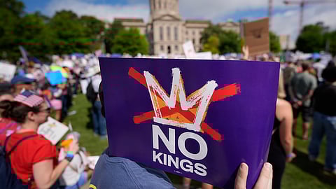 A demonstrator holds a sign during a "No Kings" protest, Saturday, June 14, 2025, in Atlanta.
