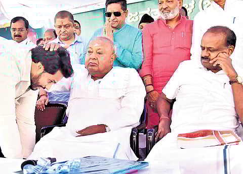JDS Youth Wing president Nikhil Kumaraswamy seeks blessings of his grandfather and party supremo HD Deve Gowda, as his father and Union Minister HD Kumaraswamy looks on in Bengaluru on Sunday