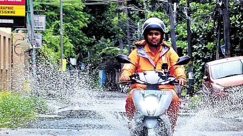 A motorist rides through a waterlogged road on Sunday after incessant rain lashed the city, leaving many areas inundated