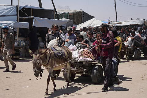 Palestinians carry bags containing food and humanitarian aid packages delivered by the Gaza Humanitarian Foundation, a U.S.-backed organization, in Rafah, southern Gaza Strip, Monday, June 16, 2025.