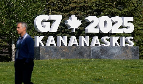 A man walks past a G7 sign outside the media centre for the G7 Summit on Sunday, June 15, 2025 in Banff, Alberta.