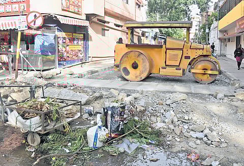 Unfinished white-topping work on Palace Guttahalli Road creates the perfect space for some to dump garbage at an intersection.
