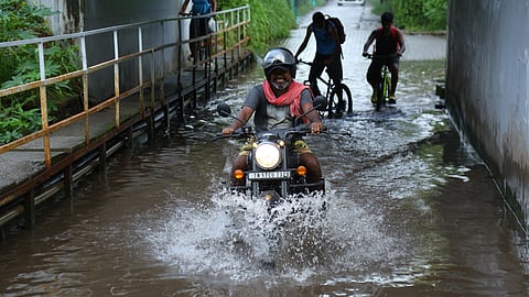 Motorist wading through the water logged Konthuruthi railway under pass in Kochi on Tuesday.