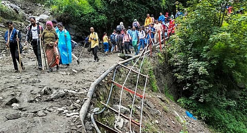People resume their journey after boulders stopped rolling down from hills near Jangalchatti, on the Kedarnath route in Rudraprayag district, Uttarakhand, Wednesday, June 18, 2025. At least two people died in the incident, according to officials.