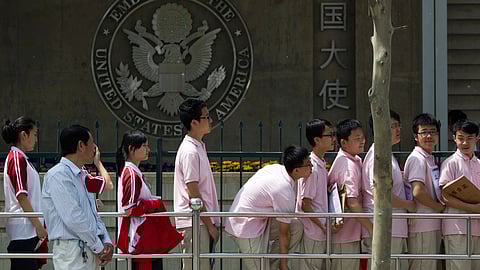 Chinese students wait outside the U.S. Embassy for their visa application interviews, in Beijing