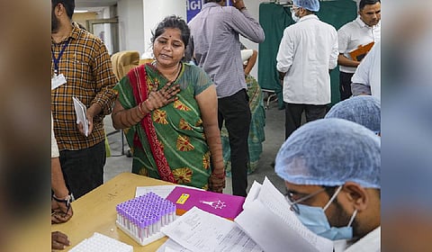 Relative of a victim of the Air India plane crash reacts as she gives her DNA sample for identification of bodies at a hospital, in Ahmedabad.