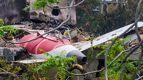 A crane removing aeroplane's tail from the wreckage after the June 12 Air India flight 171 crash, is pictured in a residential area near the airport in Ahmedabad on June 14, 2025.