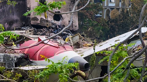A crane removing aeroplane's tail from the wreckage after the June 12 Air India flight 171 crash, is pictured in a residential area near the airport in Ahmedabad on June 14, 2025