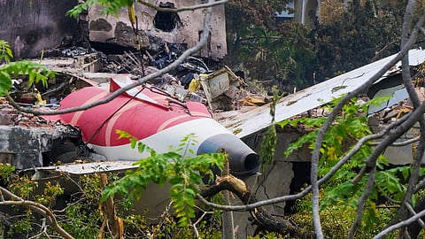 A crane removing aeroplane's tail from the wreckage after the June 12 Air India flight 171 crash, is pictured in a residential area near the airport in Ahmedabad on June 14, 2025