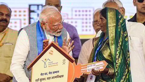 Prime Minister Narendra Modi felicitates a beneficiary during the inauguration and foundation stone laying of various development projects at a public meeting, in Siwan district