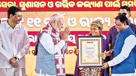 PM Narendra Modi gives a Lakhpati Didi appreciation letter to a tribal woman. Guv Hari Babu Kambhampati & CM Mohan Charan Majhi also present.